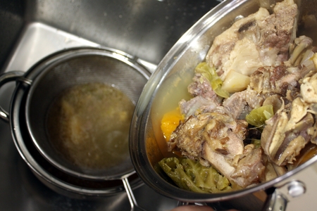 Straining the broth through a strainer