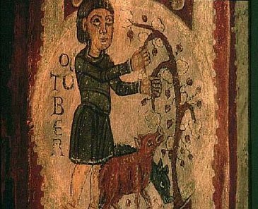 Reproducción medieval de un campesino alimentando con bellotas unos cerdos